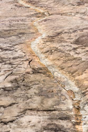 Pink rock with cream and orange channel curving vertically through image - Australian Stock Image