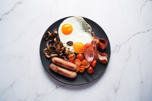 Plate of breakfast food with eggs and meat - Australian Stock Image