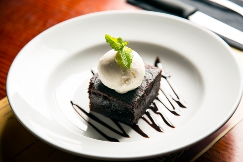 Plate of brownie and cream at a cafe - Australian Stock Image