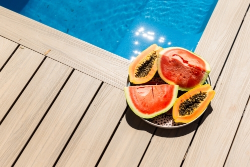 Plate of fruit by poolside - Australian Stock Image