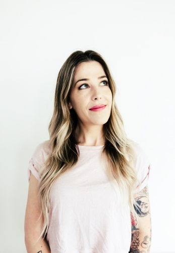 Portrait of a girl with arm tattoos looking up with space for text - Australian Stock Image