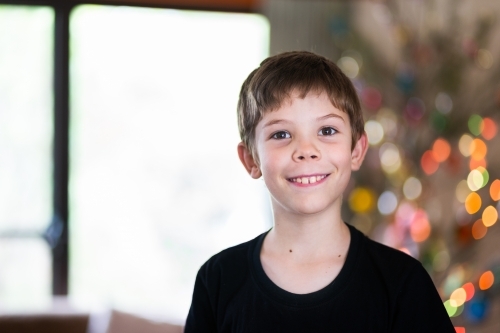 Portrait of a happy kid with brown eyes at Christmas time - Australian Stock Image