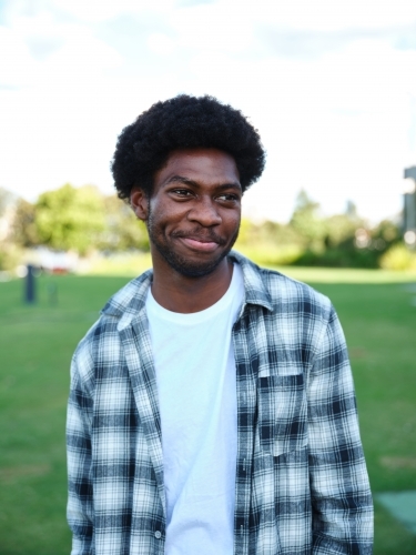 portrait of a man in a park wearing a checkered polo shirt - Australian Stock Image