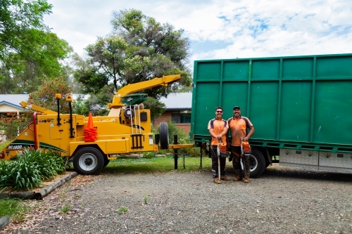 Portrait of a team of men who are tree felling lumberjacks with their chainsaws in front of truck - Australian Stock Image