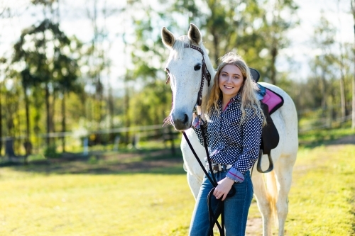 Portrait of a teen horserider in paddock with her horse and copy space - Australian Stock Image