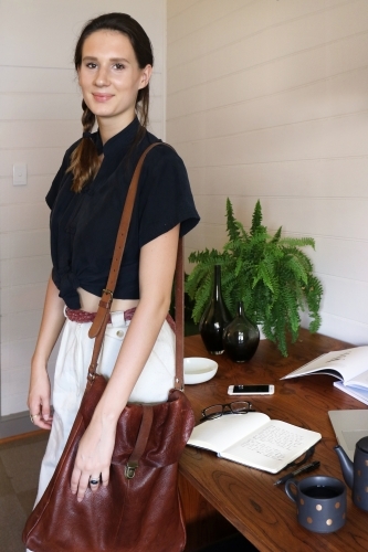 Portrait of a young creative female worker standing at her office desk - Australian Stock Image