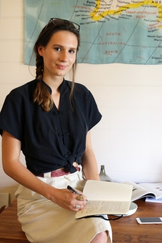 Portrait of a young female creative industry worker sitting at her desk - Australian Stock Image