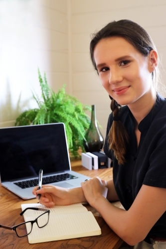 Portrait of a young female creative industry worker sitting at her desk - Australian Stock Image