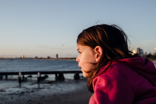 Portrait of a young girl at St Kilda beach at sunset, Melbourne, Australia - Australian Stock Image