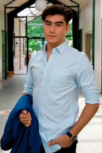 Portrait of a young male office worker standing near the exit of the building - Australian Stock Image