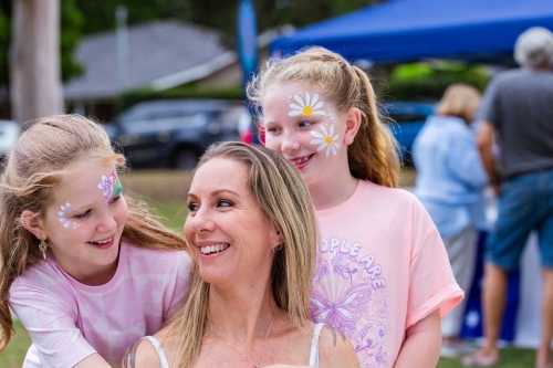 Portrait of Aussie mum and two daughters together at summer time event - Australian Stock Image