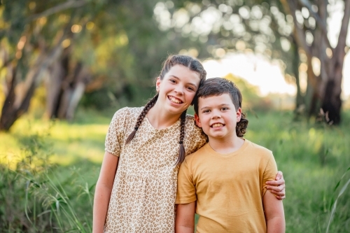 Portrait of bother and sister standing together in Australian country bush setting - Australian Stock Image