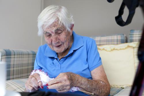 Portrait of elderly retirement village resident knitting