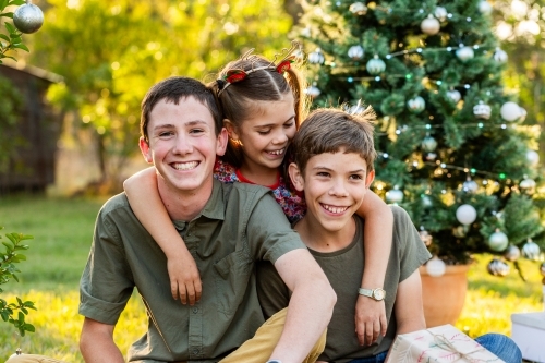 Portrait of happy kids sitting together at Christmastime - Australian Stock Image