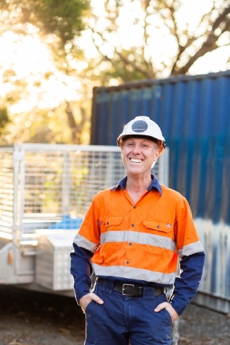 Portrait of happy smiling handyman tradie with protective headwear and high vis workwear - Australian Stock Image
