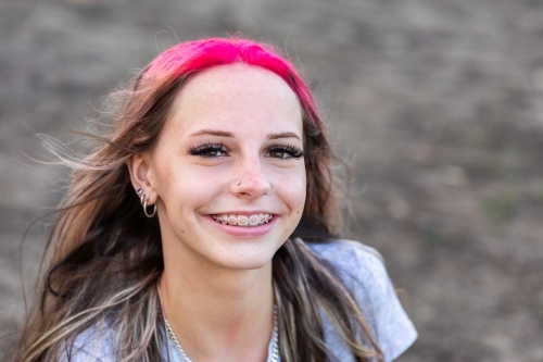 Portrait of happy teen girl with pink hair and braces - Australian Stock Image