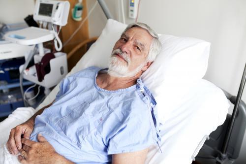 Portrait of middle aged male patient lying in a hospital ward - Australian Stock Image