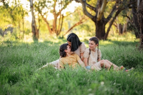 Portrait of mother and children sitting together in Australian bush setting - Australian Stock Image