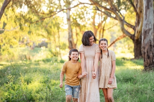 Portrait of mother and children walking together in Australian bush setting - Australian Stock Image