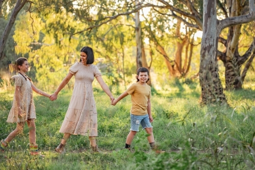 Portrait of mother and children walking together in Australian bush setting - Australian Stock Image