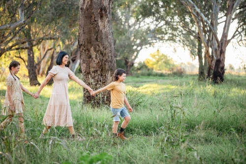 Portrait of mother and children walking together in Australian bush setting - Australian Stock Image