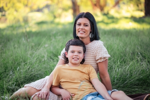 Portrait of mother and son sitting together in Australian bush setting - Australian Stock Image