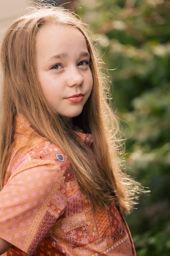 Portrait of pre-teen girl in lush garden setting - Australian Stock Image