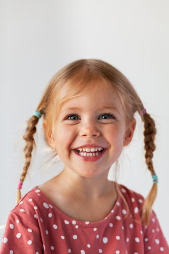 Portrait of smiling young Australian Caucasian child on white backdrop - Australian Stock Image