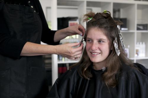 Portrait of teenage girl getting foils at a hairdresser - Australian Stock Image