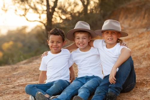 Portrait of three happy Aboriginal brothers in rural country setting - Australian Stock Image