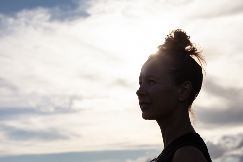 Portrait of woman looking out with sky backdrop - Australian Stock Image