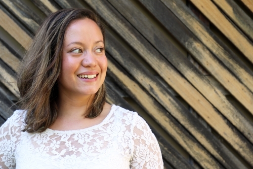 Portrait of young female outdoors with textured wooden background - Australian Stock Image