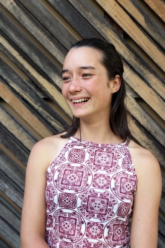 Portrait of young female outdoors with textured wooden background - Australian Stock Image