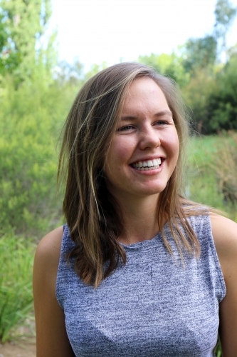 Portrait of young female outdoors with trees in background - Australian Stock Image