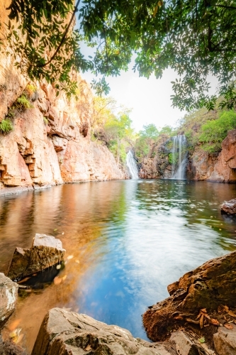 Portrait view of Florence Falls being framed by rocks and overhanging branches - Australian Stock Image