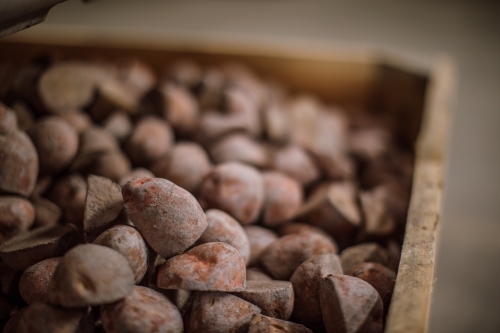 Potatoes in large wooden crate in factory - Australian Stock Image