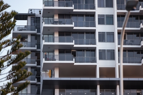 Pre-teen boy standing on balcony of high rise apartment building on the Gold Coast - Australian Stock Image