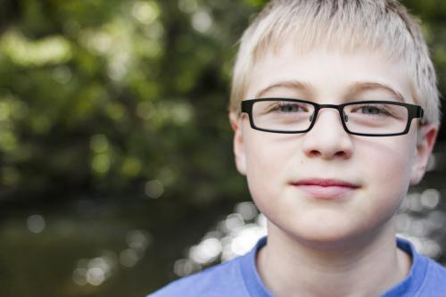 Pre-teen boy with blonde hair wearing glasses - Australian Stock Image