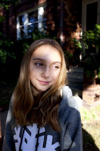 Pre teen girl smiling in the dappled sunlight - Australian Stock Image