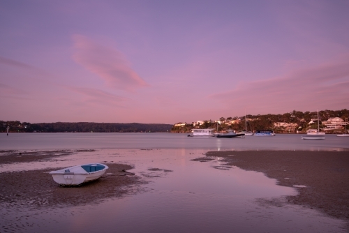 Predawn on tidal flats with stranded boat - Australian Stock Image