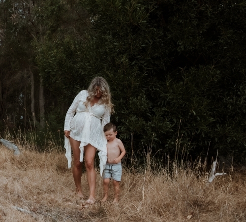 Pregnant Mother walking with son outside - Australian Stock Image