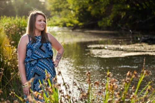 pregnant woman standing beside river - Australian Stock Image