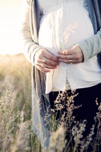 Pregnant woman standing in field - Australian Stock Image