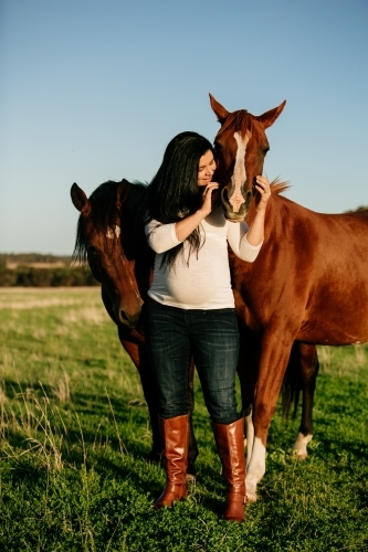 Pregnant woman with her pet horses - Australian Stock Image