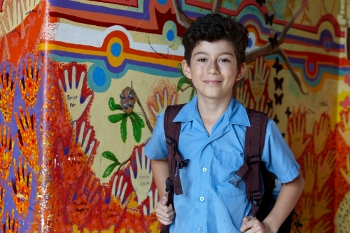 Primary school student at school, with wall mural behind - Australian Stock Image