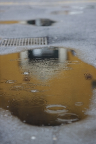 puddle on city street - Australian Stock Image