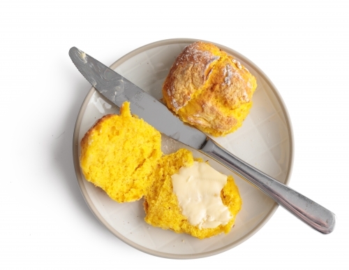 Pumpkin scones on plate with knife and butter - Australian Stock Image