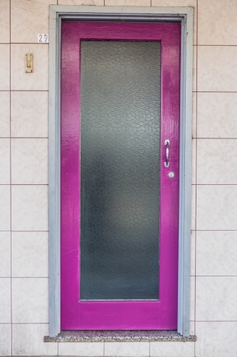 Purple door with white tiles - Australian Stock Image