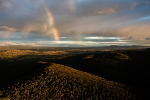 Rainbow over granite belt landscape - Australian Stock Image