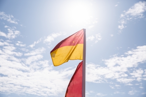 red and yellow flag with the sun behind - Australian Stock Image